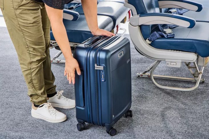 family of four in an airport terminal with matching colorful luggage set