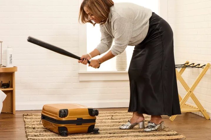 airport carry-on sizer frame with a rolling suitcase being tested against it
