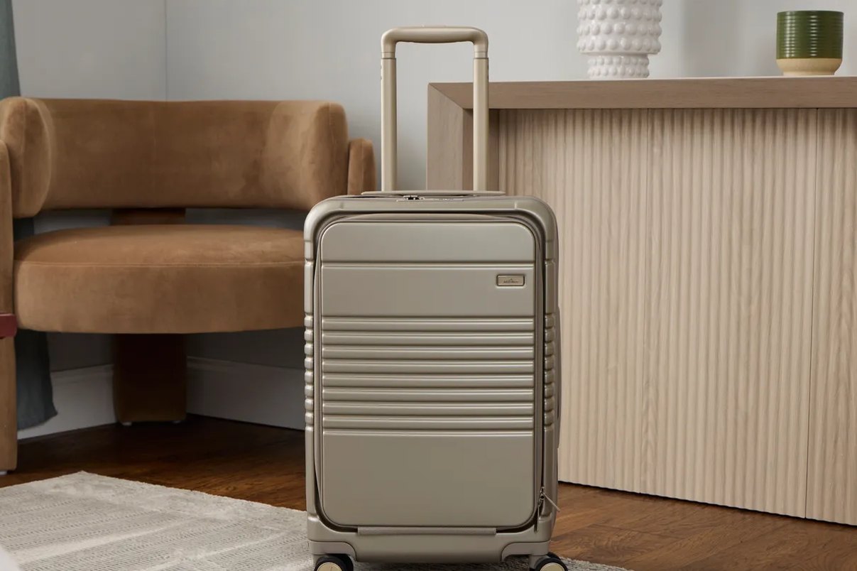 carry-on suitcase wheels shown rolling on textured airport flooring